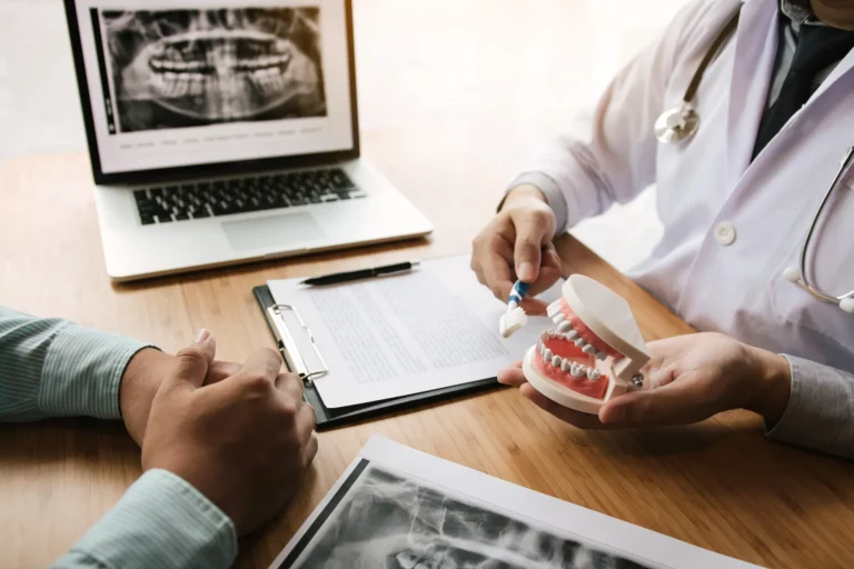 Dentist using a model and x-rays to explain treatment to a patient