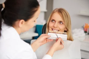 Dentist checking a patient's tooth shade before whitening